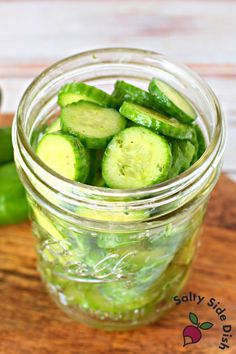 pickled cucumbers in a mason jar on a cutting board