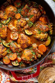 a pan filled with chicken and vegetables on top of a table