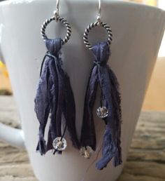 "Be on trend with our uniquely yours beaded tassel earrings! We've started with different colors of vintage ribbon, and repurposed it into our own handmade tassels--your choice of navy blue, emerald green, or khaki (one with a silver ring and the other with a copper ring). The tassels are made hanging from a nickel free ring (see your choices) and then tied with small crystal czech glass beads to give you a little bling. The drop on these earrings varies between 2.5\" and 3\", so they are not to Trendy Fringe Jewelry Gift, Trendy Fringe Jewelry As Gift, Trendy Fringe Jewelry For Gifts, Trendy Fringed Jewelry As Gift, Elegant Tassel Earrings For Festival, Trendy Summer Jewelry With Tassels, Trendy Adjustable Tassel Earrings, Trendy Festival Jewelry With Fringe, Trendy Blue Tassel Earrings With Fringe