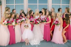 a group of women standing next to each other in front of a window holding bouquets