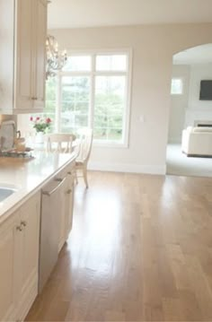 a large kitchen with white cabinets and wood flooring, along with a breakfast nook