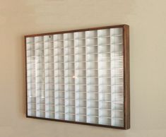 a mirror hanging on the wall in front of a white wall with a brown frame