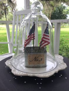 a glass clochet with an american flag in it on top of a table