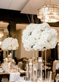 the centerpieces are filled with white flowers and candles