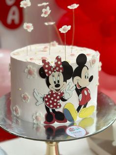 there is a cake with mickey and minnie on it