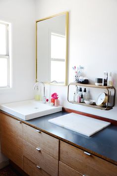 a bathroom with a sink, mirror and other items on the counter in front of it