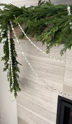 a christmas garland hanging from the ceiling next to a fireplace