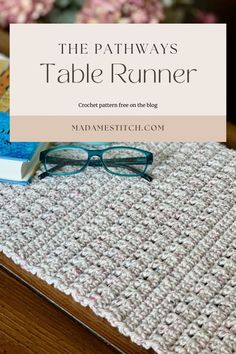 a pair of glasses sitting on top of a table next to a crocheted place mat