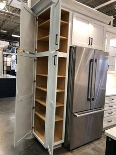 an open refrigerator and freezer combo in a showroom