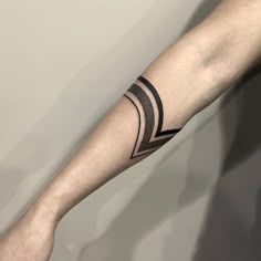 a man's arm with a black and white tattoo design on the left forearm