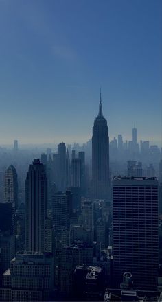 the city skyline is shown with tall buildings and skyscrapers in the foreground, as well as an airplane flying overhead