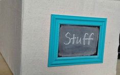 a chalkboard with the words stuff written on it next to a storage bin filled with items