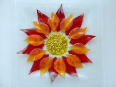 an orange and red flower with yellow center on a white background in the shape of a sunflower