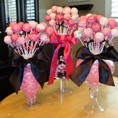 two vases filled with pink and white flowers on top of a dining room table