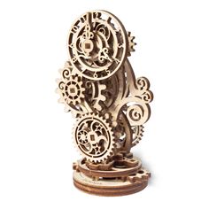 an intricate wooden sculpture with gears on it's sides, against a white background