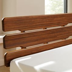 a close up of a bed with wooden slats on the headboard and foot board