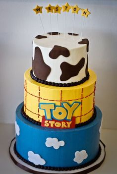 a three tiered cake decorated with toy story characters and stars on top, sitting on a table