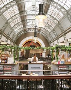 the inside of a building with lots of windows and plants on display at the counter