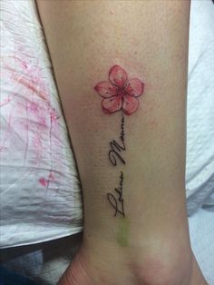 a woman's foot with a pink flower on it and the word love written in cursive writing