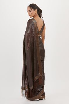 Brown saree with sequin work and fringe pallu. Paired with embroidered sleeveless blouse.
Components: 2
Pattern: Embroidered
Type Of Work: Sequin
Neckline: Plunge V Neck
Sleeve Type: Sleeveless
Fabric: Chiffon
Color: Brown
Other Details: 
Sequin work
Embroidered blouse
Occasion: Sangeet,Reception - Aza Fashions Glamorous Georgette Pre-draped Saree For Celebration, Glamorous Silk Saree With Sequins, Silk Pre-draped Saree With Sequins For Party, Silk Pre-draped Party Saree With Sequins, Glamorous Silk Pre-draped Saree With Sequins, Sleeveless Sequined Pre-draped Saree For Diwali, Diwali Party Saree With Side Open, Sleeveless Saree For Diwali Evening, Celebration Pre-draped Saree With Sequins In Traditional Drape