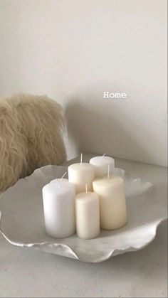 a white plate with some candles on it and a dog looking at the candle holders