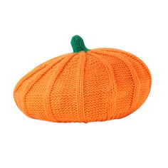 an orange knitted pumpkin sitting on top of a white surface