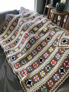 a crocheted blanket sitting on top of a couch