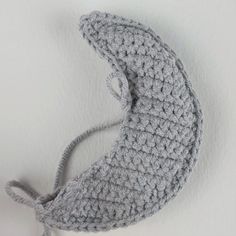 a crocheted hat hanging on the wall next to it's ear hole