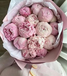 a bouquet of pink peonies sitting on top of a table