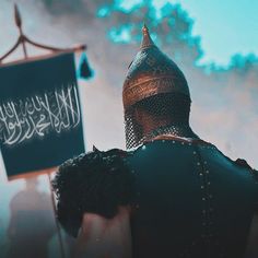 a man in armor holding a sign with writing on it