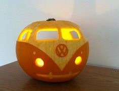 a carved pumpkin with a vw bus on it's face and lights in the eyes