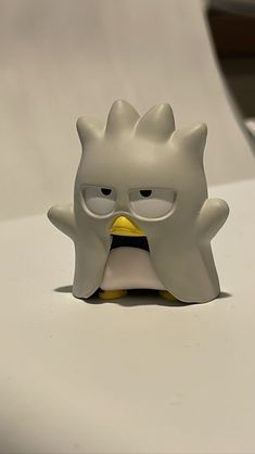 an angry bird figurine sitting on top of a white table next to a computer mouse