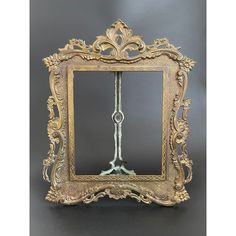 an ornate gold framed mirror sitting on top of a table