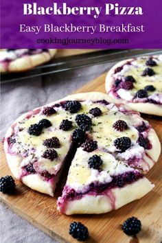 homemade blackberry cheesecakes with blackberries cut in half on a cutting board next to some cookies