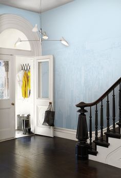 a hallway with blue walls and wooden floors