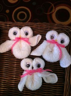 three stuffed owls sitting on top of a wicker basket