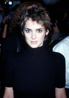 a close up of a person wearing a black shirt and looking at the camera with an intense look on her face