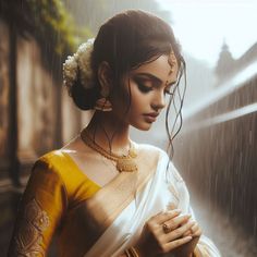 a woman in a yellow and white sari is holding her hands to her chest