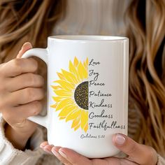 a woman holding a white coffee mug with a sunflower on the front and side