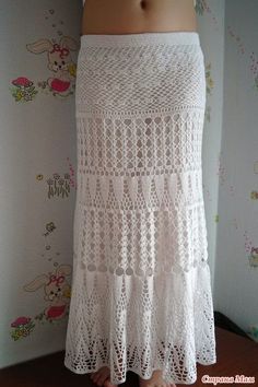 a white crochet skirt is shown in front of a wall