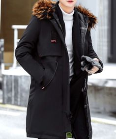 a man in black coat walking down the street