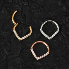 Description: A triangle septum ring is always the best choice for those who want to make your nose look more three-dimensional. Improve the glamour of your septum piercings with the simple elegance of this 16 gauge clicker jewelry! It features a triangle V shape at the bottom of the hoop, paved on V-shape front facings with clear cubic zirconia gems. Once you've tried out this V-shape septum ring, you won't ever want to go back to boring old jewelry for your septum jewelry! Clicker Design: The h Septum Jewelry Clicker, Gold Septum, Septum Hoop, Tragus Ring, Septum Piercings, Piercing Septum, Daith Earrings, Conch Earring, Septum Jewelry