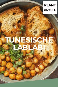 a bowl filled with chickpeas and bread on top of a table