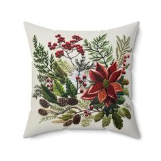 a white pillow with red poinsettia and pine cones