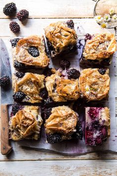 a cutting board topped with blueberry pies and berries