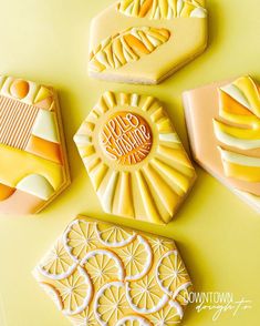 four decorated cookies sitting next to each other on a yellow table top with the words happy birthday written in white