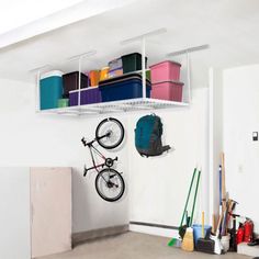 a bike hanging from the ceiling in a room with shelves and other items on it