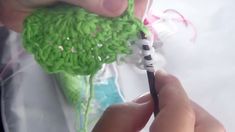 someone is crocheting something green with scissors