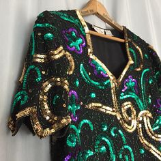 Sequin Shirt Black Green Gold Purple Sequins Vintage Laurence Kazar Silk Top Women's Large  Best Fit: Women's Medium or Large - compare measurements for best fit. Size Marked: Women's Large Brand: Laurence Kazar Materials: 100% Silk  Made in: India Details: A beautiful vintage black silk shirt with sequins across the front and back. Flower shapes and swirl patterns. Beading along the edges. Slight distress including a few missing beads and sequins as shown. See photos for best details of this fa Green Sequined Short Sleeve Tops, Fitted Green Sequined Blouse, Fitted Short Sleeve Festive Tops, Festive Fitted Short Sleeve Tops, Fitted Short Sleeve Tops For Festive Occasions, Vintage Green Blouse For Party, Black Silk Shirt, Black Leather Mini Skirt, Flower Shapes