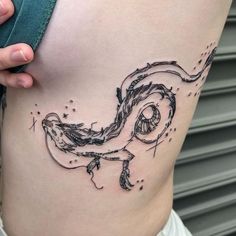 a woman's stomach with a bird tattoo on her side, and stars in the sky